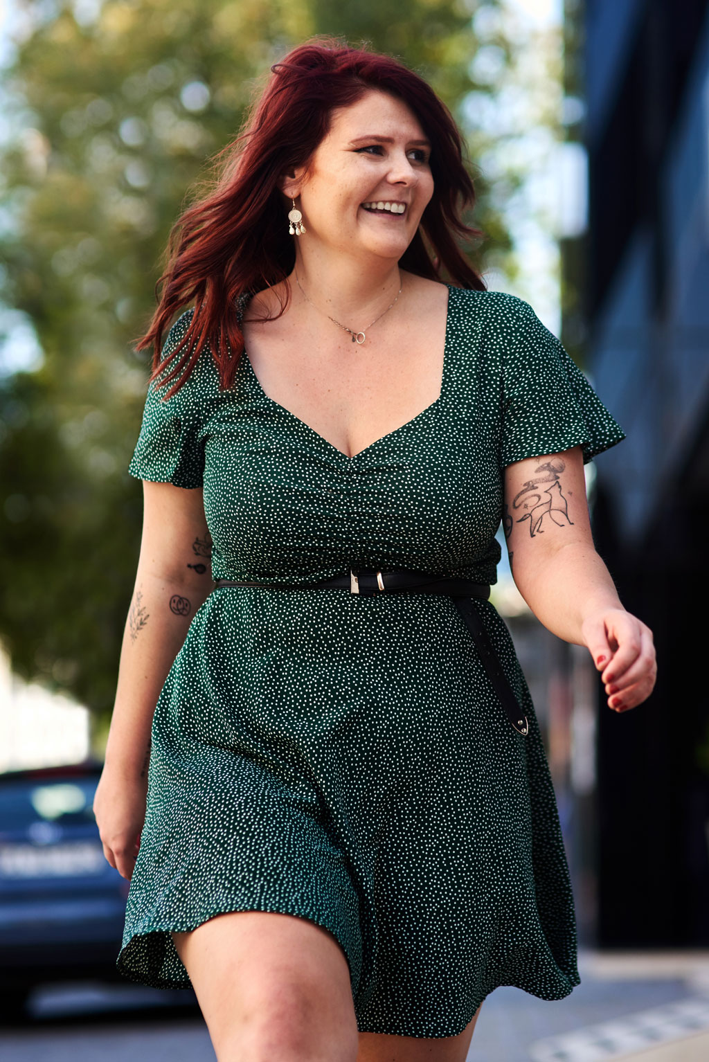 smiling woman strolling in a green polka dot dress 2026 03 25 05 02 30 utc